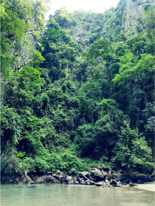 Emerald lagoon, beach, limestone cliff and jungle inside Emerald Cave