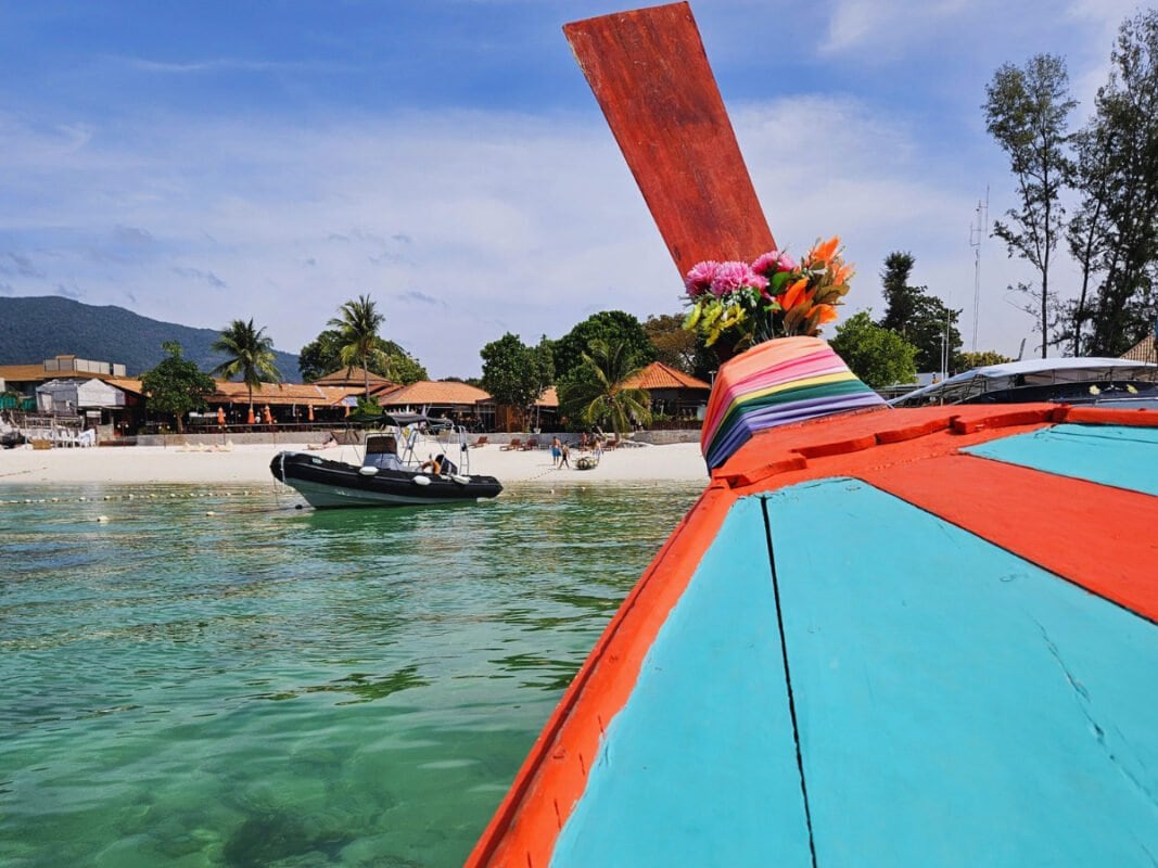 View from the boat sailing to the Pattaya Beach, Koh Lipe. Clear water, beach, boats and buildings in the distance