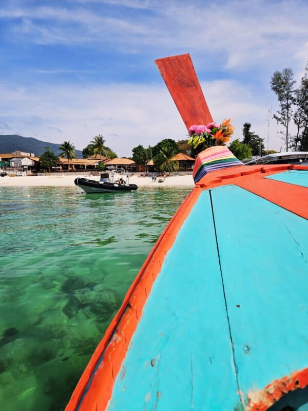 View from the boat sailing to the Pattaya Beach, Koh Lipe. Clear water, beach, boats and buildings in the distance