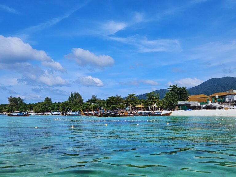 Boats and turquoise water near Pattaya Beach, Koh Lipe. Mountains in the distance