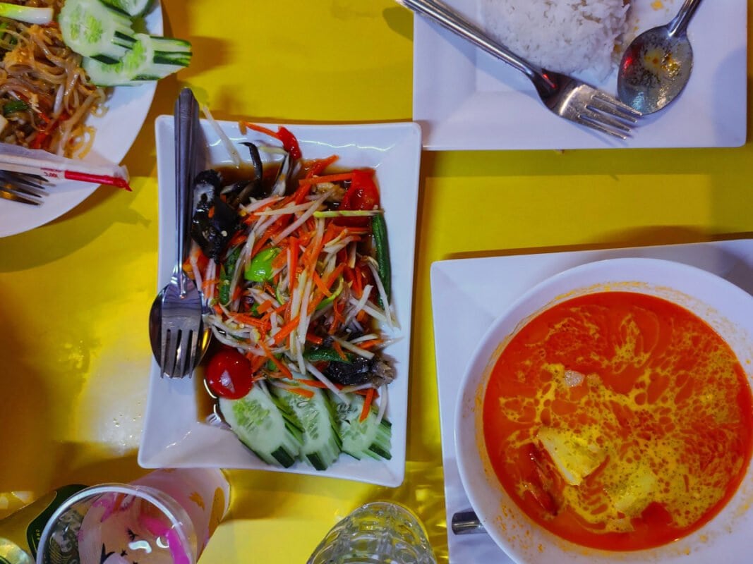 On the table Papaya salad, soup, padthai and drinks at Koh Lipe