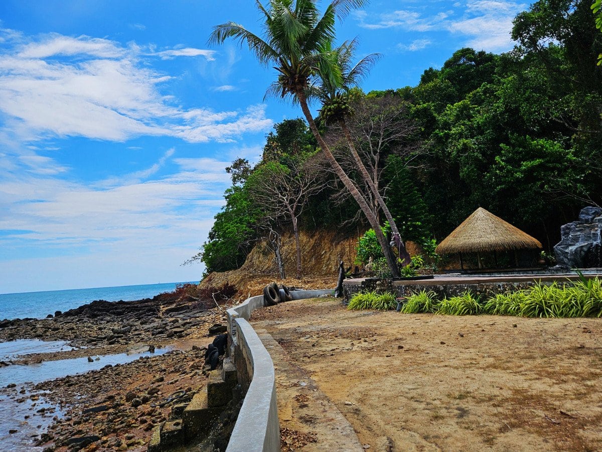 rocky coastline with palm trees on koh lanta west coast thailand