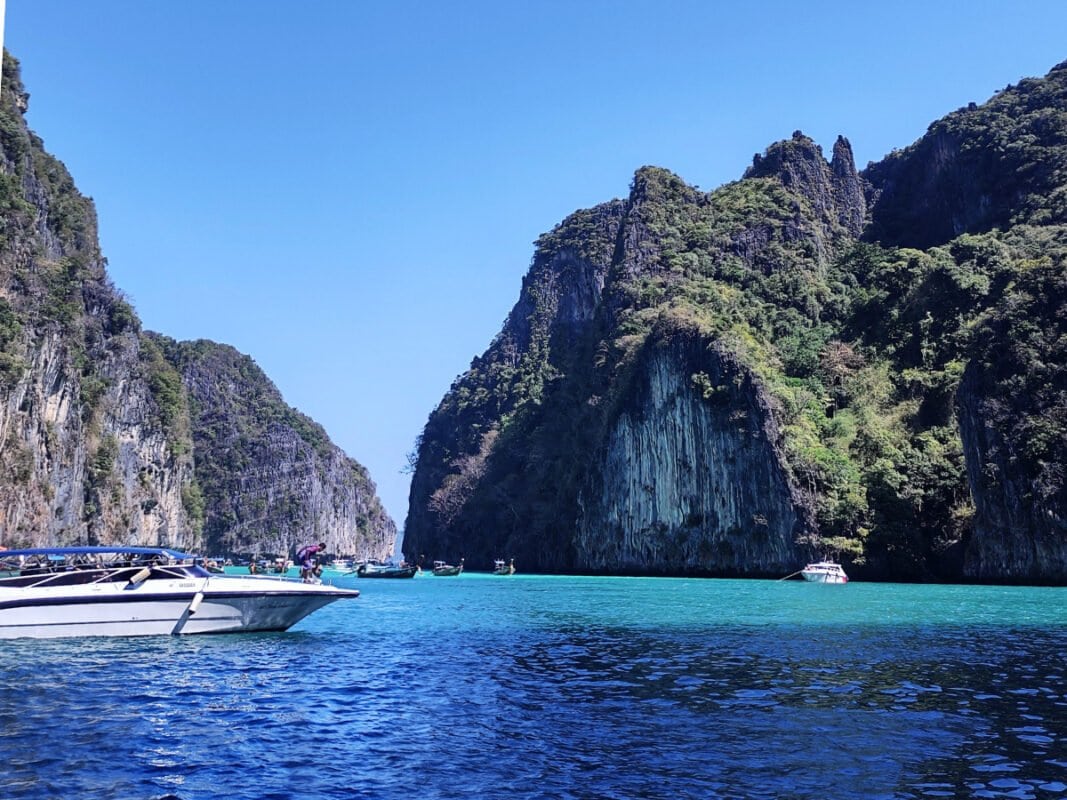 Snorkeling spot near Koh Phi Phi, boats and limestone cliffs in the distance