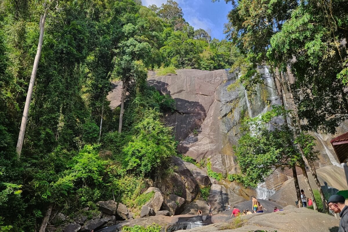 view of the 7 wells waterfall in the jungle of Langkawi, people walking and swimming