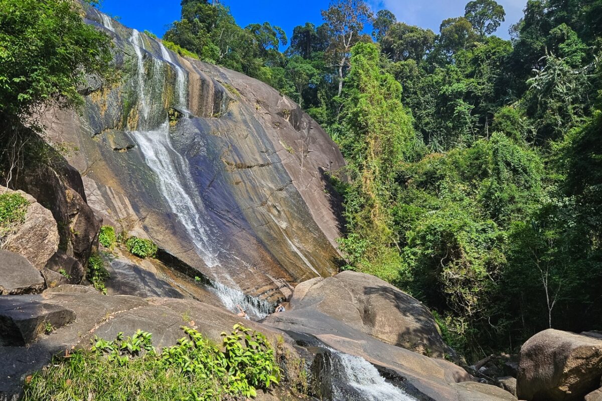 Water flowing down the stones on the 7 wells waterfall, Langkawi; jungle around