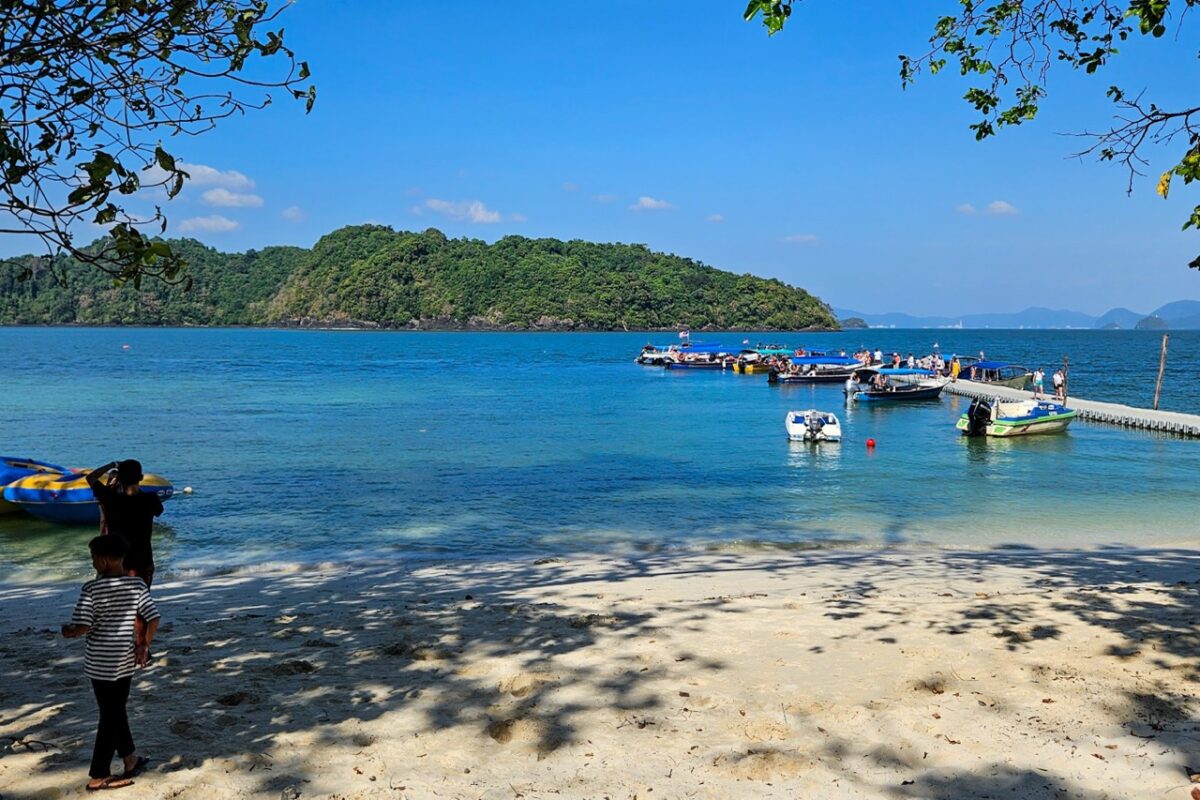 A wide shot of a tropical bay with speedboats docked at a floating pier.