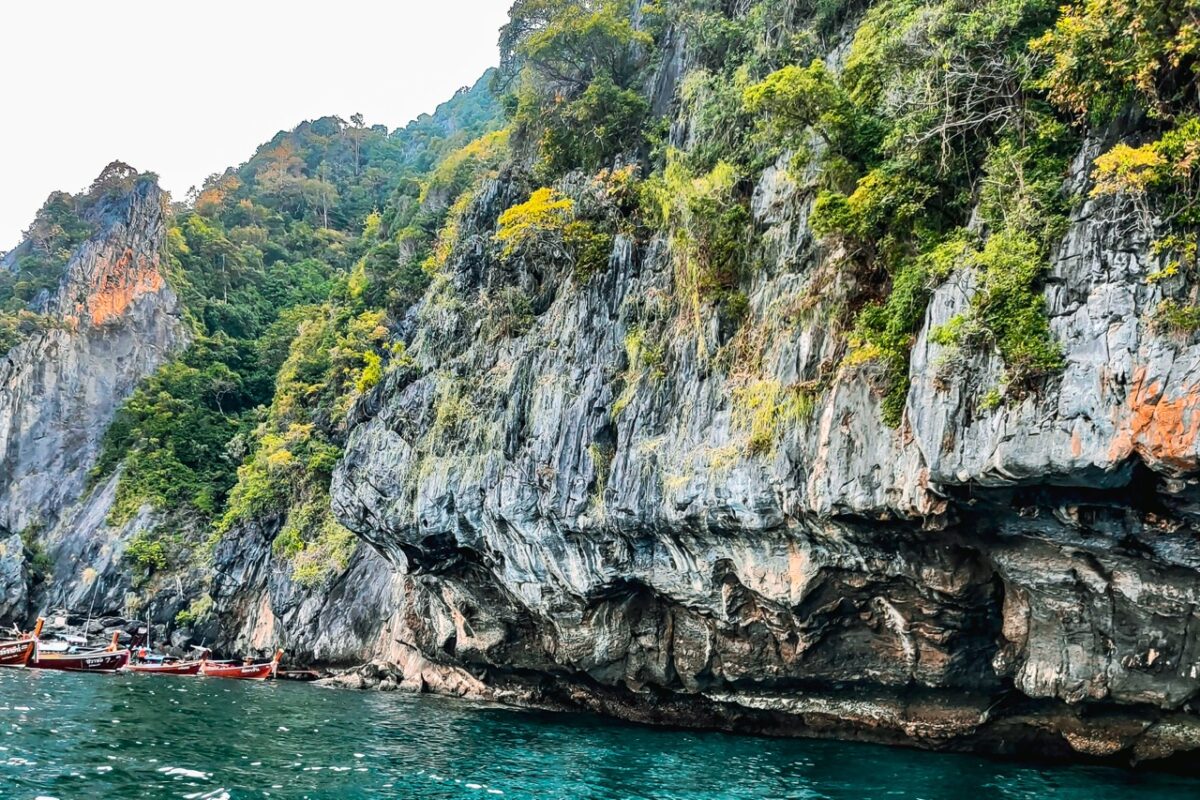 longtail boats near emerald cave cliffs koh mook thailand