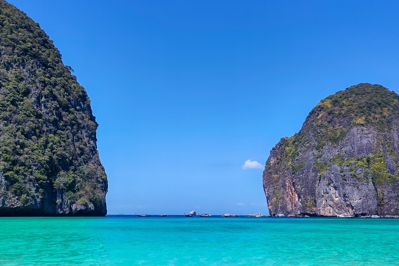 boats traveling between limestone cliffs near koh phi phi in southern, most popular way How to Travel Between Islands in Southern Thailand