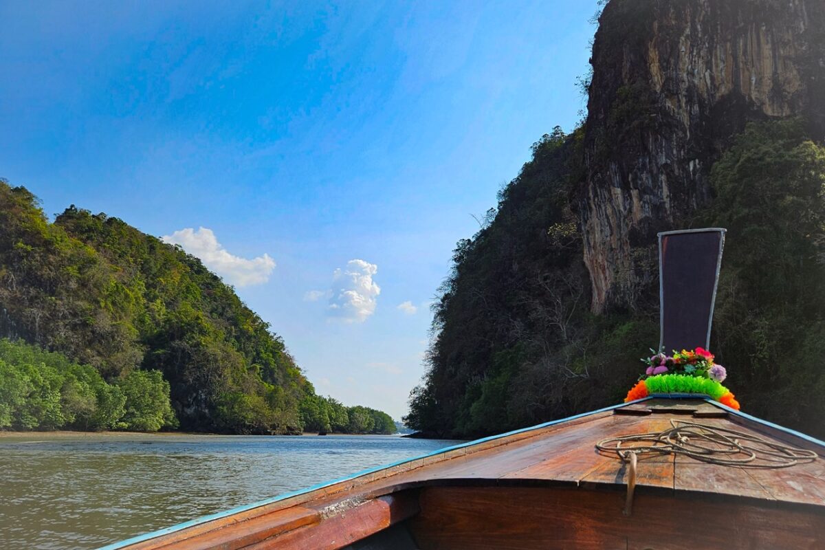 longtail boat traveling between limestone cliffs near krabi thailand