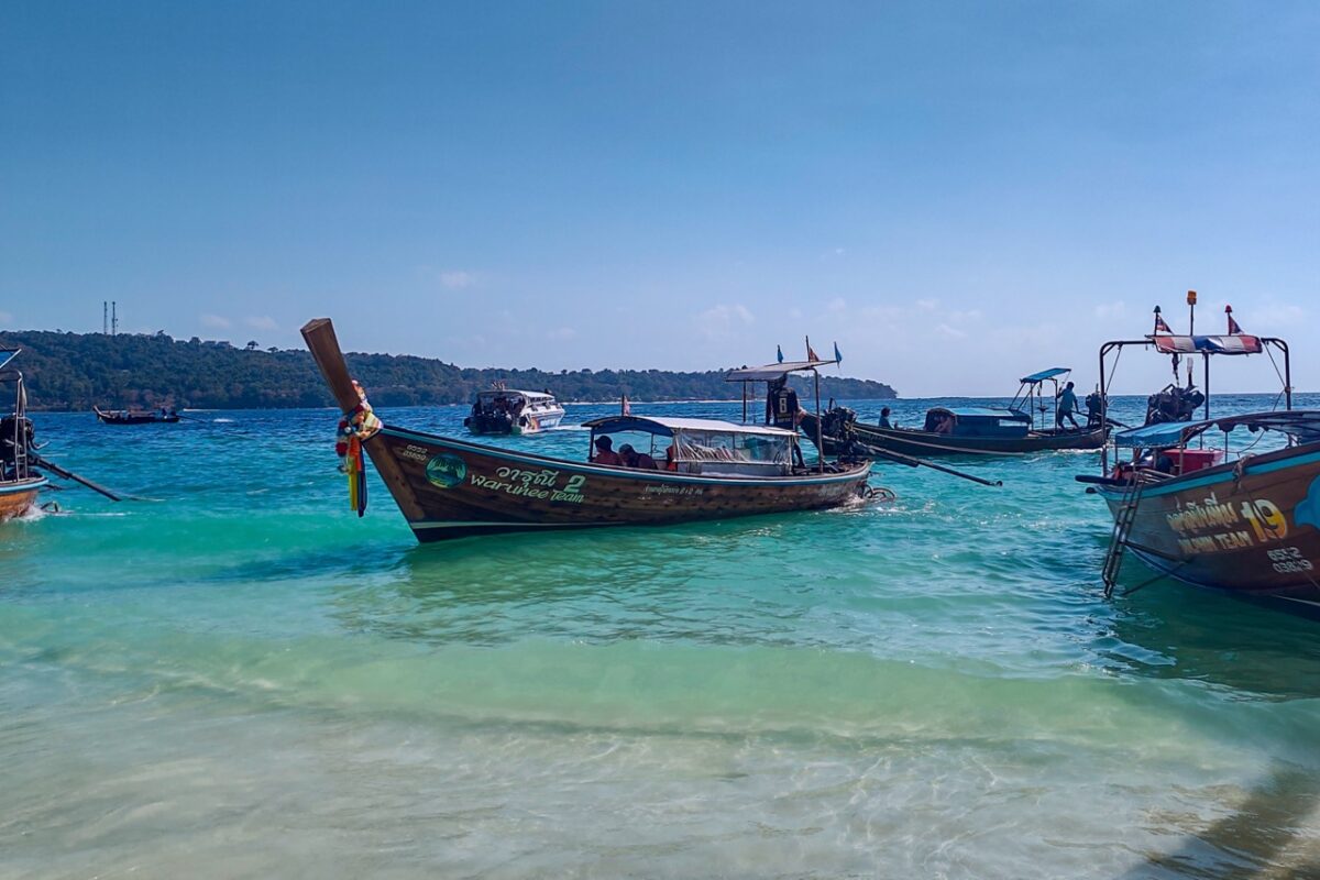 traditional longtail boats floating in turquoise water near koh phi phi thailand