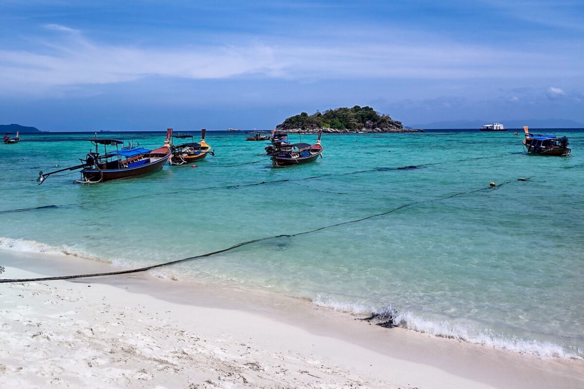 Sunrise beach one of the best beaches in Koh Lipe with turquoise water and traditional longtail boats in Thailand