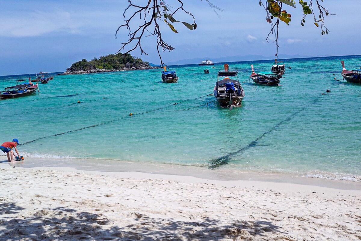 Sunrise Beach Koh Lipe with turquoise water and traditional longtail boats in Thailand