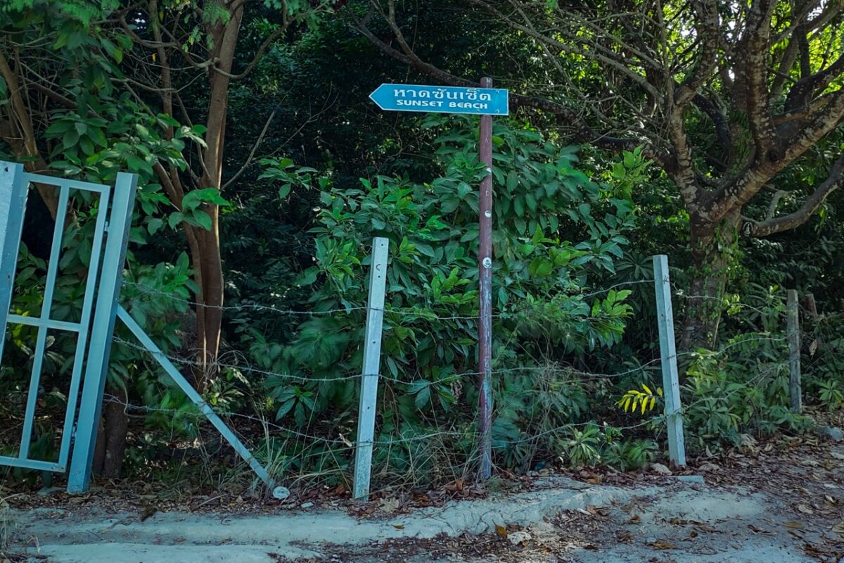 Sign pointing to Sunset Beach in Koh Lipe Thailand, jungle, village road